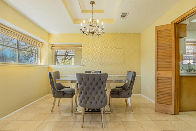 dining space featuring visible vents, baseboards, wallpapered walls, a tray ceiling, and an accent wall