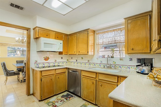 kitchen featuring white microwave, visible vents, a sink, electric stovetop, and stainless steel dishwasher