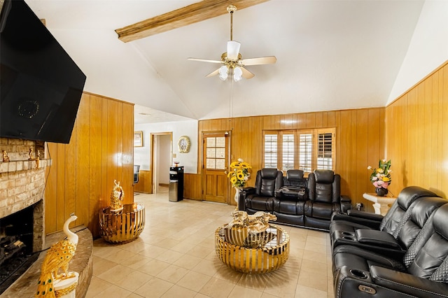 living room featuring wooden walls, a brick fireplace, ceiling fan, beam ceiling, and wainscoting