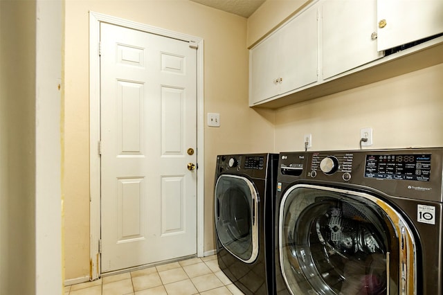 laundry area featuring cabinet space, washing machine and dryer, and light tile patterned flooring