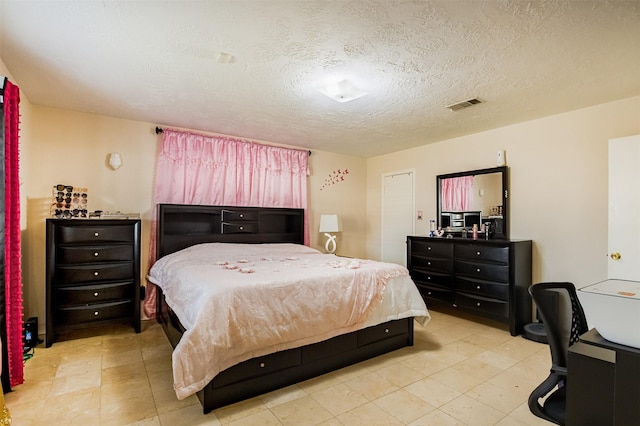 bedroom with visible vents and a textured ceiling