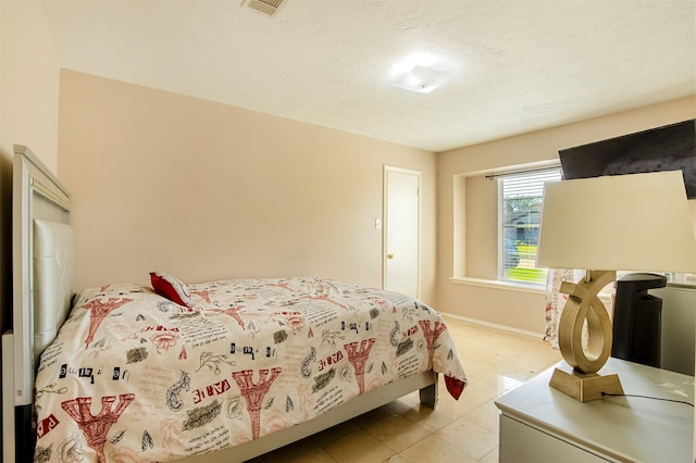 bedroom with visible vents, baseboards, and a textured ceiling