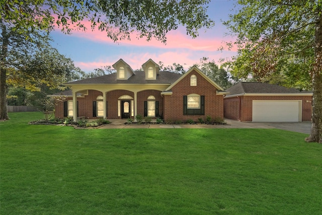 view of front of property featuring brick siding, an attached garage, concrete driveway, and a front yard