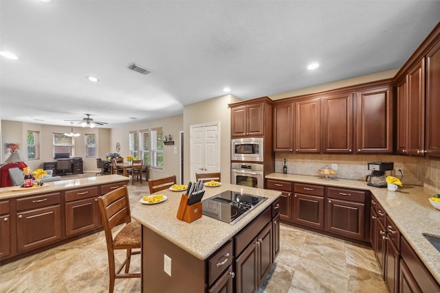 kitchen with light stone countertops, tasteful backsplash, and stainless steel appliances