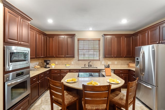 kitchen with backsplash, a kitchen bar, recessed lighting, stainless steel appliances, and a sink