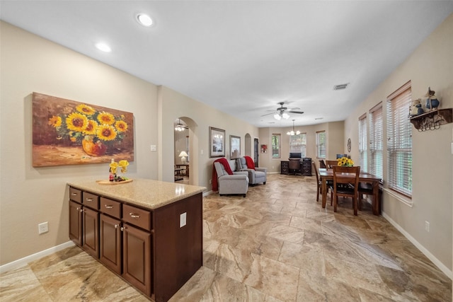 kitchen with baseboards, arched walkways, visible vents, and ceiling fan