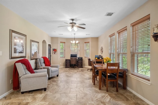 dining space with arched walkways, visible vents, ceiling fan with notable chandelier, and baseboards