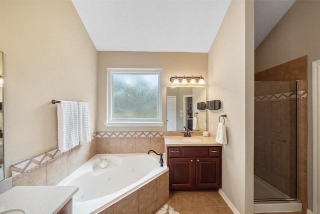 bathroom featuring vanity, a jetted tub, a shower stall, and tile patterned flooring