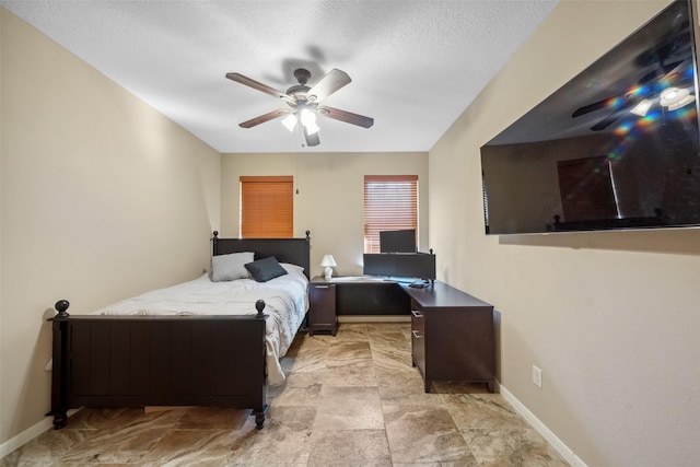 bedroom featuring a ceiling fan, baseboards, and a textured ceiling