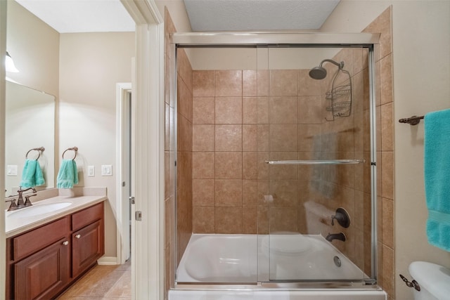 bathroom featuring tile patterned flooring, toilet, vanity, and bath / shower combo with glass door