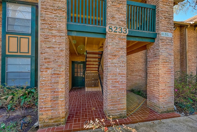 property entrance featuring brick siding and a balcony