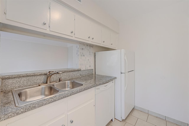 kitchen featuring a sink, white appliances, white cabinets, light tile patterned floors, and decorative backsplash