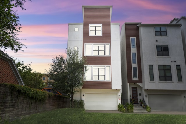 multi unit property with a garage and stucco siding