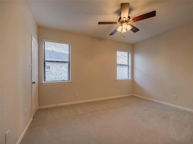 unfurnished room with baseboards, light colored carpet, and ceiling fan