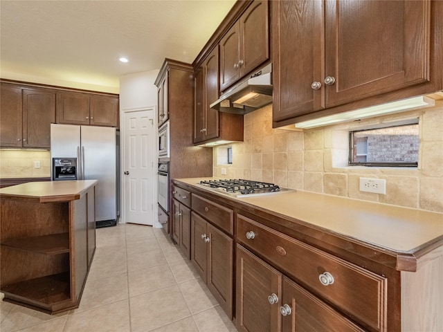 kitchen with open shelves, light tile patterned flooring, stainless steel appliances, decorative backsplash, and under cabinet range hood