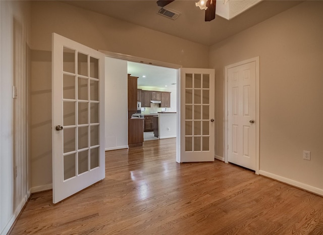 unfurnished room featuring visible vents, french doors, a ceiling fan, and wood finished floors