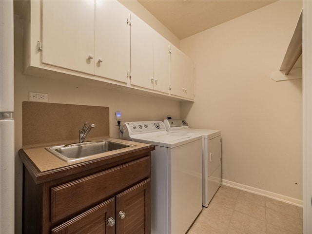 clothes washing area featuring a sink, baseboards, cabinet space, and washer and dryer