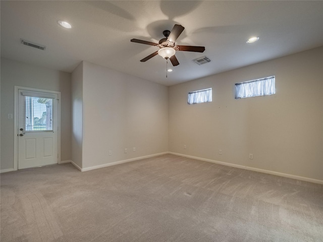 unfurnished room with recessed lighting, visible vents, light colored carpet, and a wealth of natural light