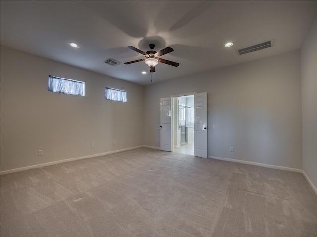 unfurnished room with light colored carpet, visible vents, and baseboards