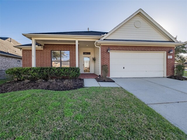 single story home featuring a garage, a front yard, brick siding, and driveway