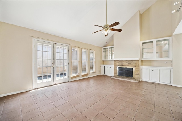 unfurnished living room with light tile patterned flooring, a fireplace, french doors, and ceiling fan