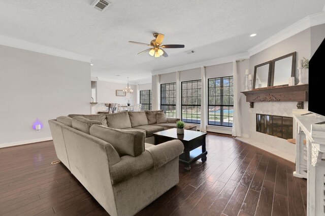 living area featuring visible vents, ornamental molding, a high end fireplace, baseboards, and dark wood-style flooring