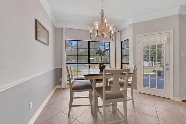 dining space featuring baseboards, a notable chandelier, ornamental molding, and light tile patterned flooring