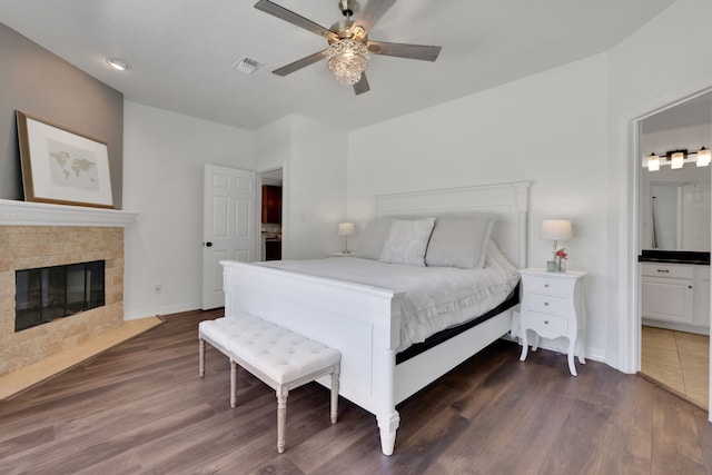 bedroom with visible vents, a fireplace with flush hearth, baseboards, and dark wood-style flooring