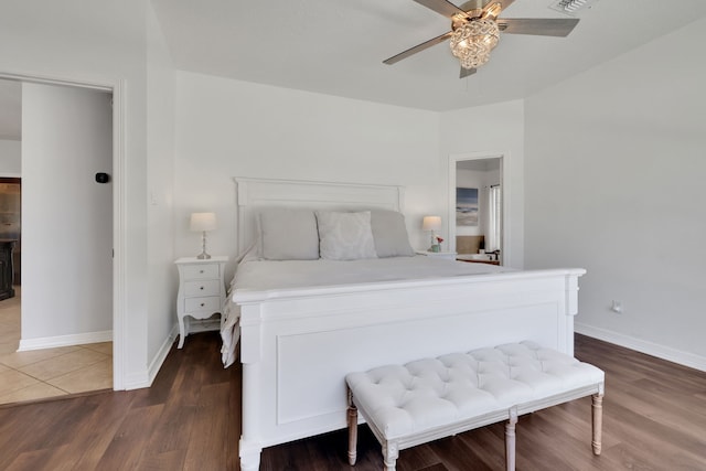 bedroom featuring visible vents, baseboards, a ceiling fan, and dark wood-style flooring