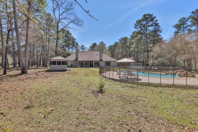 view of yard featuring a fenced in pool, fence, and a sunroom