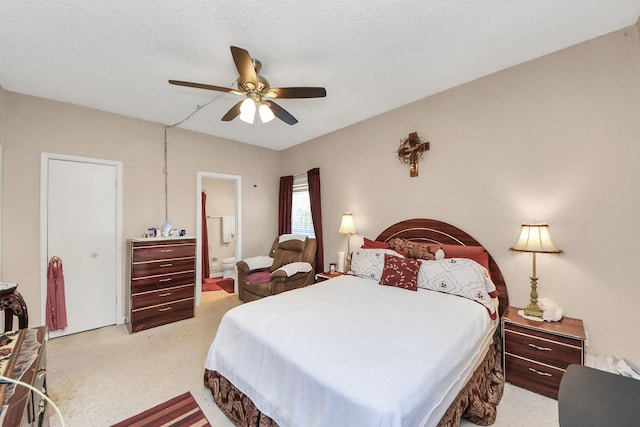 bedroom with connected bathroom, light colored carpet, and ceiling fan