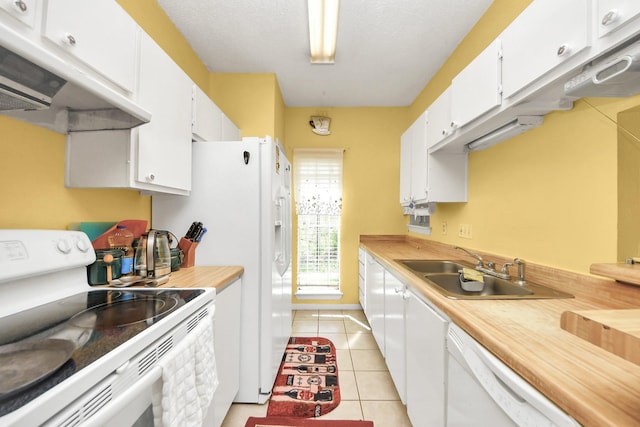 kitchen featuring a sink, ventilation hood, white appliances, white cabinets, and light tile patterned floors