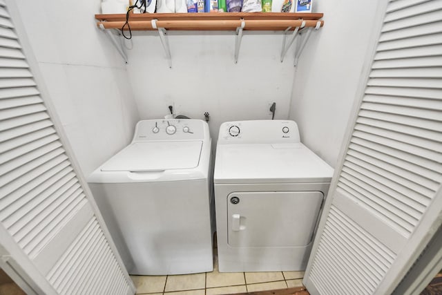 washroom featuring light tile patterned floors, laundry area, and washer and dryer