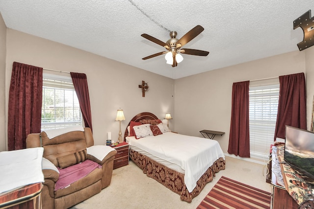 bedroom featuring carpet, ceiling fan, and a textured ceiling