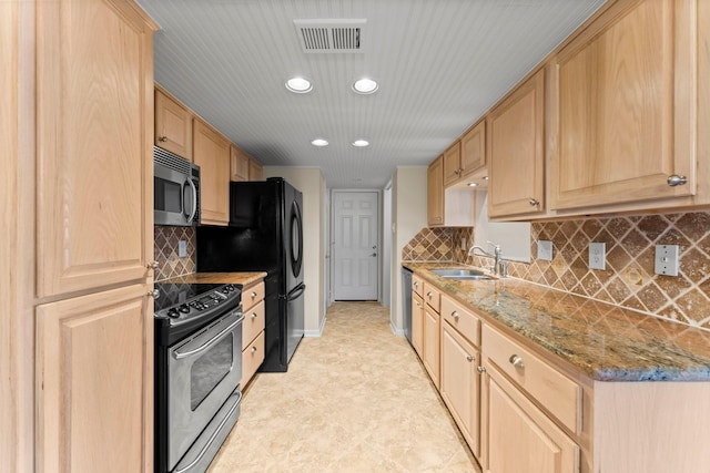 kitchen featuring light stone counters, light brown cabinets, visible vents, a sink, and stainless steel appliances