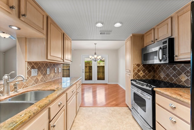 kitchen with a sink, visible vents, appliances with stainless steel finishes, and light brown cabinets