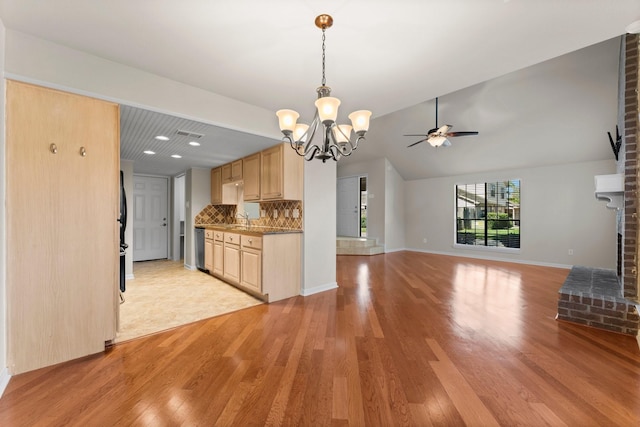 kitchen featuring light brown cabinetry, a sink, tasteful backsplash, light wood finished floors, and vaulted ceiling