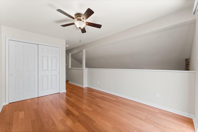 additional living space featuring baseboards, lofted ceiling, light wood-style floors, and ceiling fan