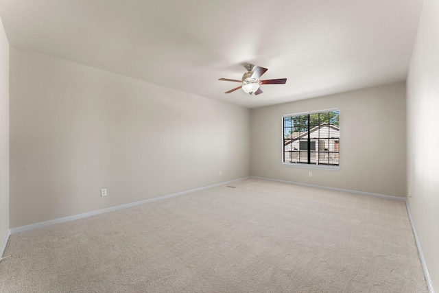 unfurnished room with baseboards, light colored carpet, and ceiling fan