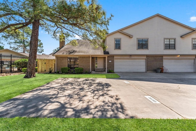 view of front of property featuring a front yard, fence, driveway, a chimney, and brick siding