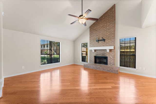 unfurnished living room with a ceiling fan, light wood-style flooring, a fireplace, and a wealth of natural light