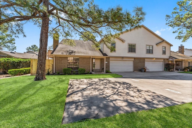 view of front of home with driveway, an attached garage, a front yard, brick siding, and a chimney