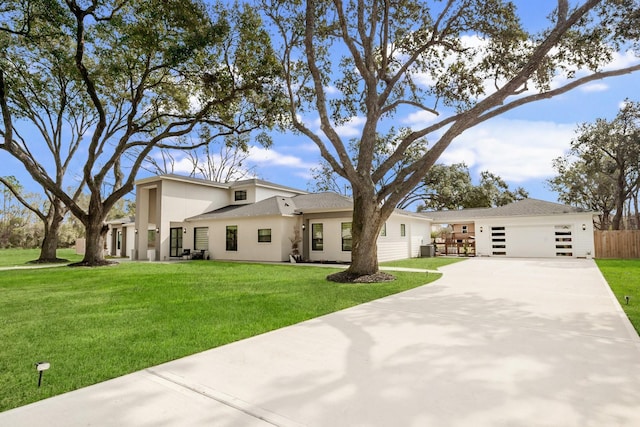 mid-century home with a garage, stucco siding, a front lawn, and fence