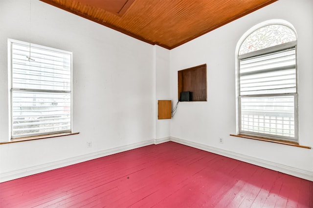 empty room with baseboards, wooden ceiling, and dark wood finished floors