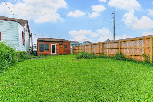 view of yard featuring an outdoor structure and a fenced backyard