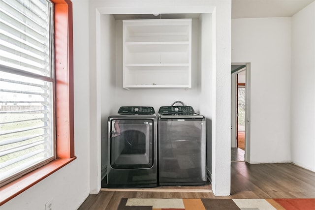 washroom with a wealth of natural light, laundry area, wood finished floors, and washing machine and clothes dryer