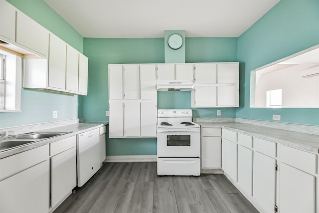 kitchen featuring under cabinet range hood, white cabinetry, white appliances, light wood finished floors, and light countertops