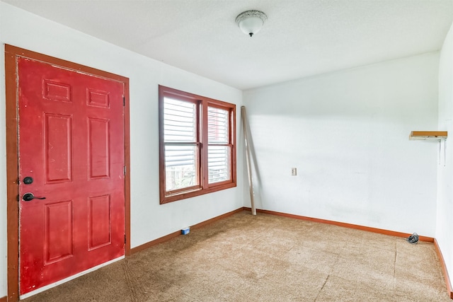 entryway with baseboards and carpet floors