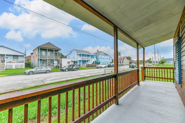 wooden terrace featuring a residential view and a porch