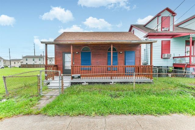 view of front of house featuring a shingled roof, a front lawn, a fenced front yard, a porch, and a gate